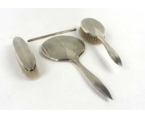 A silver mounted and engine turned dressing table set including a mirror, two brushes and a comb mount, Birmingham 1953