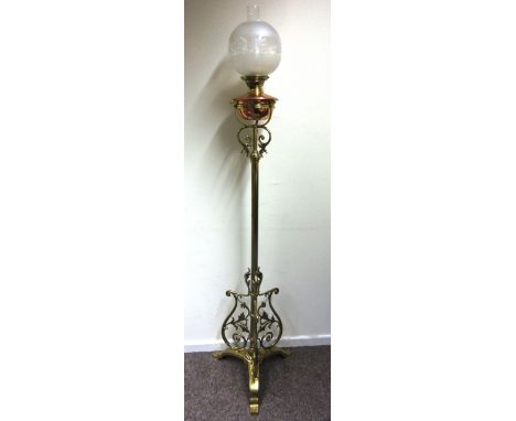 A late 19th century brass adjustable oil lamp stand with foliate design scrolls on tri form base. h. 135 cm with a copper and