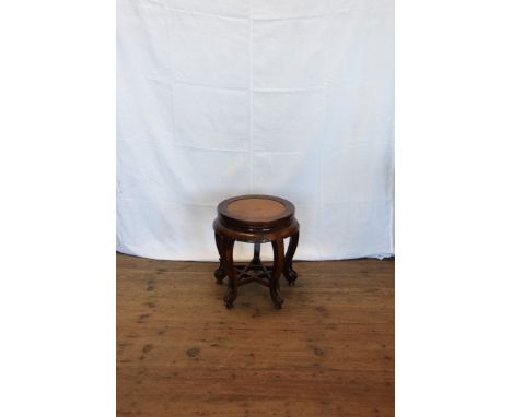 A Chinese hardwood circular stool with scroll carved frieze, on cabriole legs, pierced leaf decorated toes and with a pierced