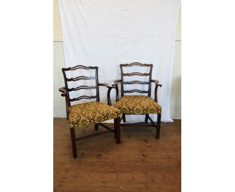 A pair of 19th century mahogany elbow chairs with pierced ladder backs, shaped out-swept arms, down-swept arm supports, over-