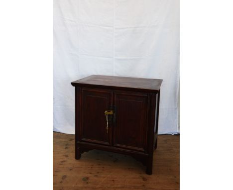 A Chinese yew cupboard with two panelled doors opening to reveal an interior shelf, on bracket feet.  31ins wide.  Est £50-70