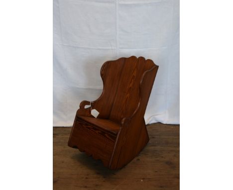 A child's late Victorian pitch pine rocking chair with commode form seat.  Est £30-50