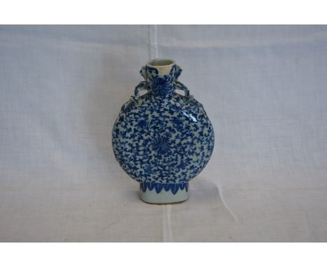 A mid 18th century Chinese blue and white moon flask with stylised dragon form handles and all-over leaf decoration (af).  10