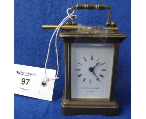A small Matthew Norman of London brass carriage clock with Roman numeral full depth enamel face and key.(B.P. 24% incl. VAT) 