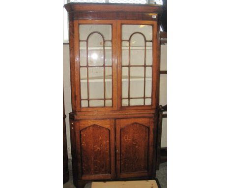 Early 19th Century oak two stage corner cabinet on shaped apron front and bracket feet.(B.P. 24% incl. VAT)