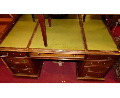 A circa 1900 mahogany and green leather inset twin pedestal partner's desk, having an arrangement of nine drawers opposing th