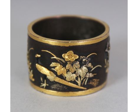 A SMALL GOOD QUALITY JAPANESE MEIJI PERIOD INLAID BRONZE RING, the sides finely decorated in relief in gilt and silver metals