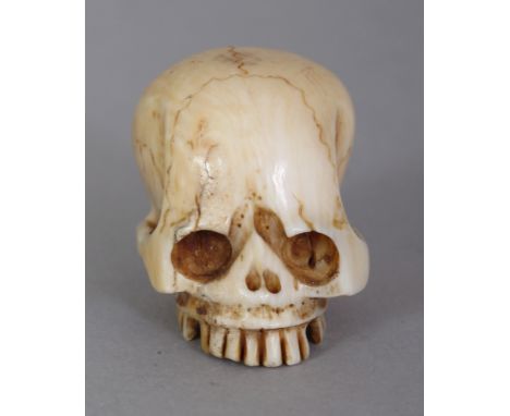 A GOOD JAPANESE MEIJI PERIOD IVORY SKULL NETSUKE, carved and engraved naturalistically, the underside engraved with a Tomoyuk