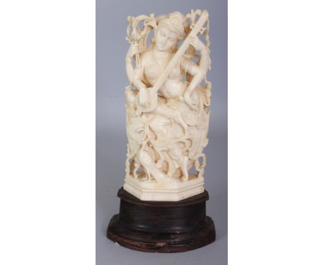 A GOOD QUALITY 19TH/20TH CENTURY CARVED INDIAN IVORY OF SARASWATI, together with a fixed wood stand, the Goddess seated on lo