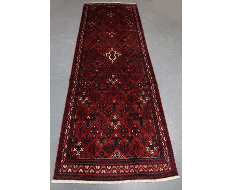A Joshaghan runner, North-west Persia, mid-20th century, the red field with an angular medallion and overall floral sprays, w