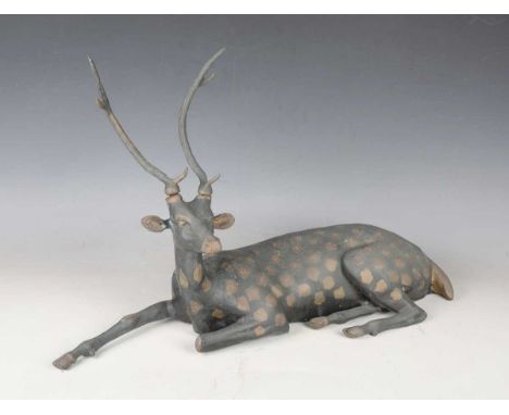 A 20th century patinated cast bronze model of a recumbent deer, length 61cm.