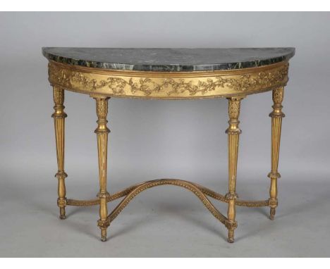 A George III Neoclassical giltwood demi-lune console table, the veined marble top above a trailing leaf frieze, raised on flu