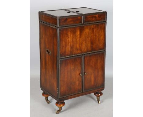 A late 20th century hardwood and brass bound campaign style drinks cabinet, the double-hinged top opening to reveal a rising 