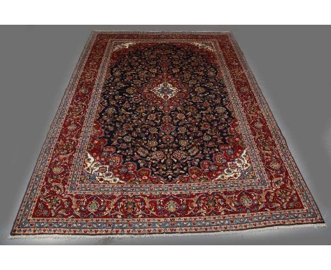 A Kashan carpet, Central Persia, late 20th century, the midnight blue field with a shaped red medallion, within a red complim