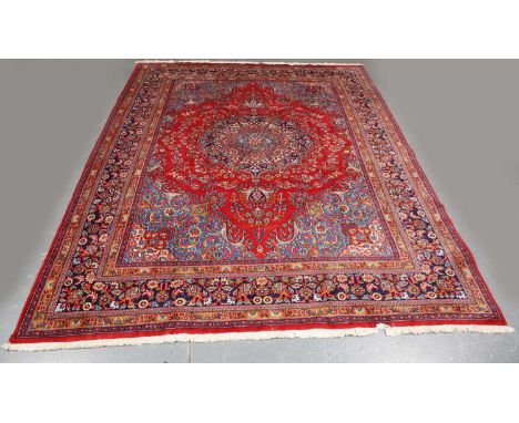 A Mashad carpet, Central Persia, late 20th century, the red field with a flowerhead medallion, within a complimentary border,
