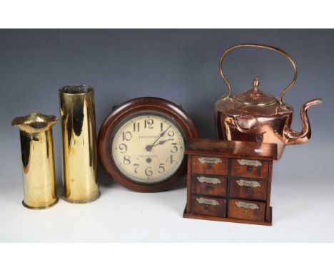 A Victorian copper kettle, two brass shell cases, a set of spice drawers and a circular wall clock.