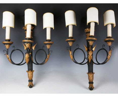 A pair of early 20th century Neoclassical Revival black and gilt painted three-light wall sconces, the back plates of arrow q