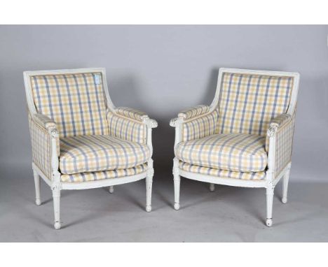 A pair of early 20th century Louis XVI style white painted showframe fauteuil armchairs, height 96cm, width 75cm, depth 76cm.