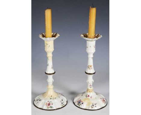 A pair of 18th century South Staffordshire enamel candlesticks, painted with floral sprigs on a white ground, height 25cm (fa