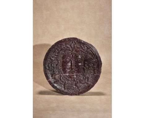 A recessed relief sculpted porphyry roundel depicting the face of Medusa, probably a Grand Tour souvenir, late 18th century, 