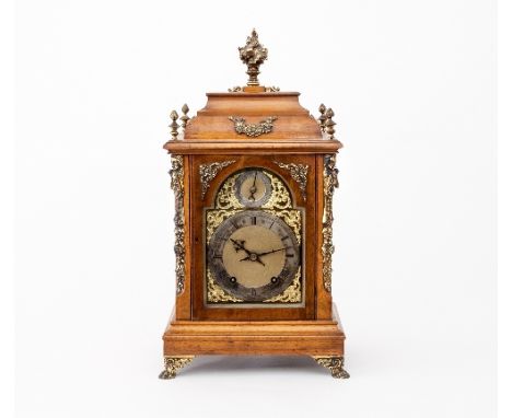 An Edwardian walnut and gilt metal mounted eight-day mantel clock, the case with flame finial and grilles to the sides fitted