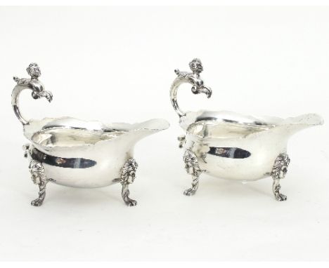 A pair of silver sauce boats, Sheffield 1929, each with caryatid scroll handle and face mask feet, 18cm wide, approximately 8