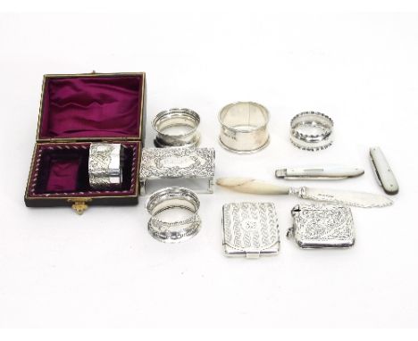 A folding silver matchbook case, Birmingham 1924, with engine turned decoration, a silver vesta case (damaged), four silver n
