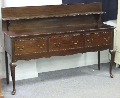 An oak dresser base of three drawers, with single shelf gallery back on front cabriole legs, 173cm wide