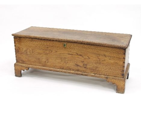 An elm chest with plain hinged cover on bracket feet, 125.5cm wide    