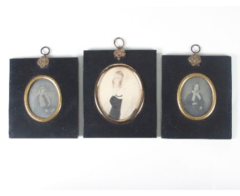Three Victorian framed ovals, containing two black and white photographs and one watercolour portrait