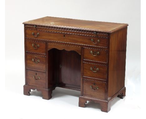 A late 18th Century Chippendale period mahogany kneehole desk, the rectangular top with moulded border, fitted a brushing sli