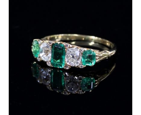 An emerald and diamond five-stone ring, the alternating stones in a scroll setting to a gold shank, ring size N
 Condition Re