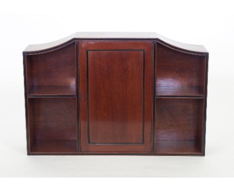 A set of mahogany wall shelves, the central section fitted with a single panel door flanked by two-tier open shelves, 77cm wi