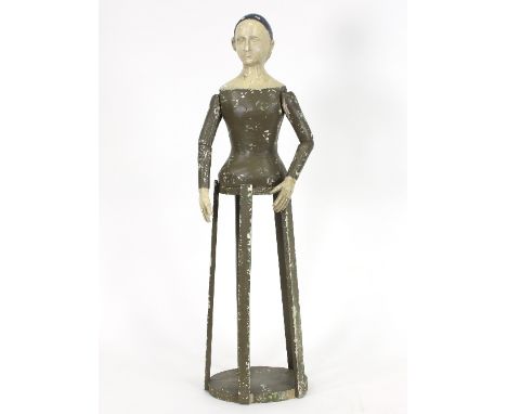 A painted mannequin with articulated arms on a wooden stand, 83cm high Condition Report: This Mannequin is offered for sale b