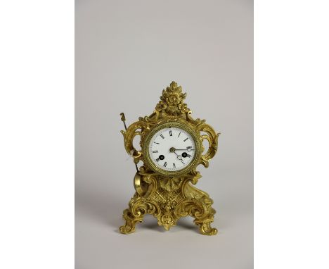 A 19th Century French ormolu Boudoir Clock, in the rococo style with enamel dial and Roman numerals, raised on scroll legs, 9