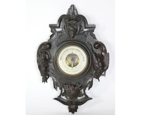 A carved and stained oak "Black Forest" type Aneroid Barometer, decorated with dog and wolf, dead game and fish, approx. 76cm