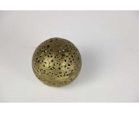 A rare pierced brass ball shaped 19th Century hand Warmer, the interior with a swivel oil lamp, 7.5 cms (3"). (1)