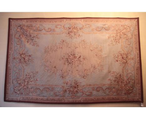 A large 19th Century French Aubusson Tapestry, the sky blue ground centre with an oval floral bouquet, framed within an ornat