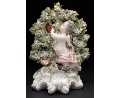 A DERBY FIGURAL CANDLESTICK OF CUPID  in flowered drapery and kneeling on a mound before bocage pointing to the flaming heart