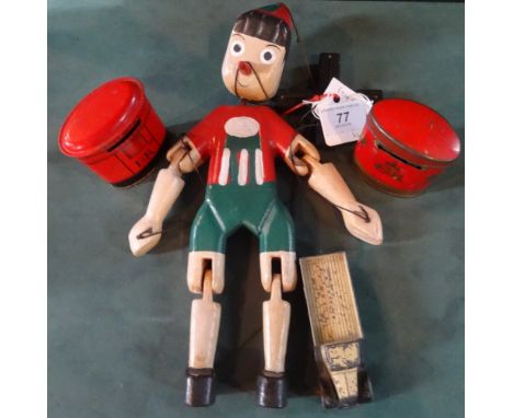 A mid-20th century wooden Pinocchio puppet, together with a Dinky Toys flatbed truck and two novelty tin money boxes fashione