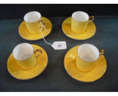A set of four Wedgwood coffee cans and saucers, numbered 5164, having vibrant yellow decoration with gilt finish.