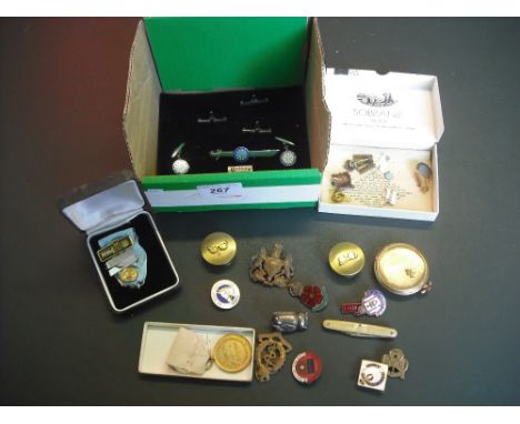 A small quantity of collectable items to include: military uniform badges, brass and enamel pin badges, a gilt metal cased po