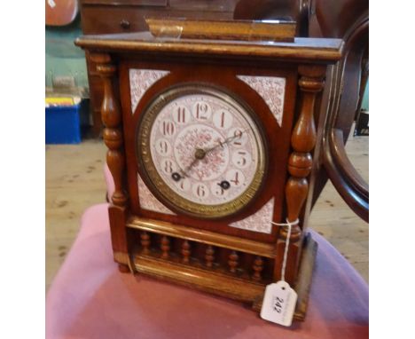 An early 20th century oak cased mantle clock, the ceramic dial having floral decoration, bearing Arabic numerals, 29cm.