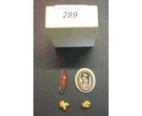 Two yellow metal nuggets, together with a Limoges porcelain portrait brooch and a silver backed decorative brooch.