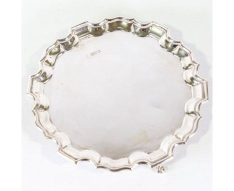 A George V silver salver, circular form with scalloped rim and claw and ball feet, maker's mark SI, hallmarks Sheffield 1930,