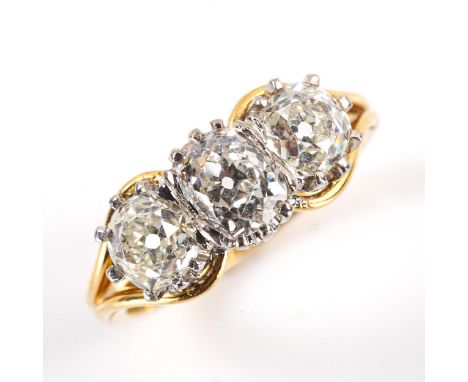 A late 20th century 18ct white and yellow gold 3-stone diamond ring, claw-set with cushion old cut and old cut diamonds, tota