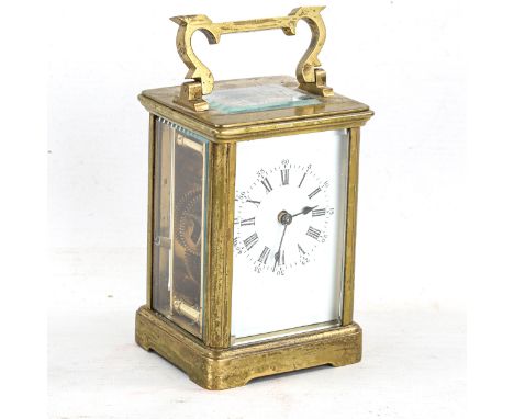 A brass-cased carriage clock, white enamel dial with Roman numeral hour markers, and glass exhibition plates, case height 11c