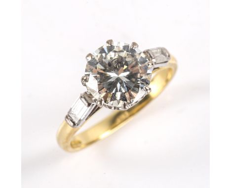 A modern 18ct gold 2.6ct solitaire diamond ring, set with principal modern round brilliant cut diamond with baguette cut diam