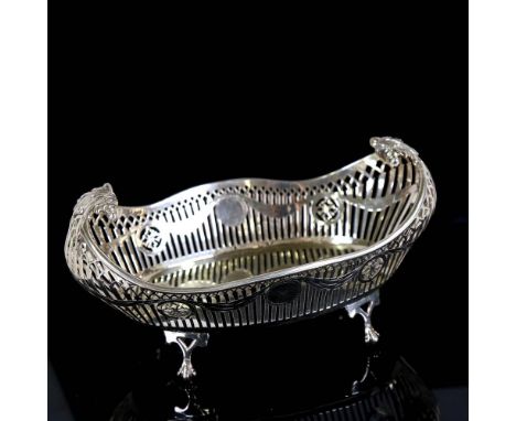 A George V silver cake basket, oval form with scrolled handles, pierced gallery and engraved Adam's style swag decoration, by