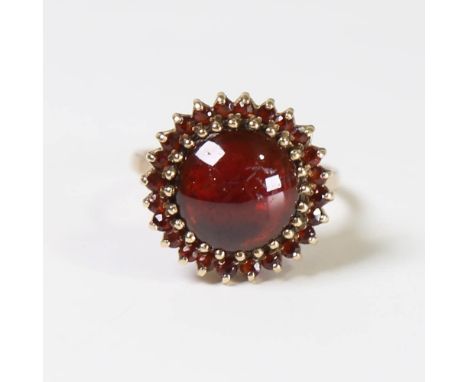 A late 20th century 9ct gold garnet cluster ring, set with round cabochon garnet surrounded by round cut garnets, hallmarks L